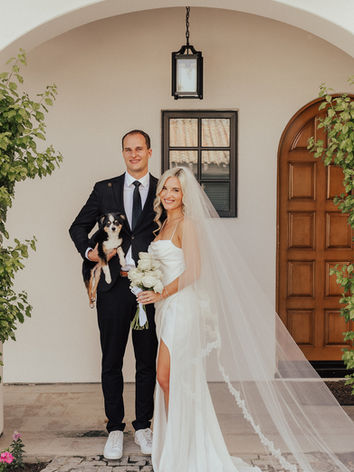 Bride and groom pose with their small dog