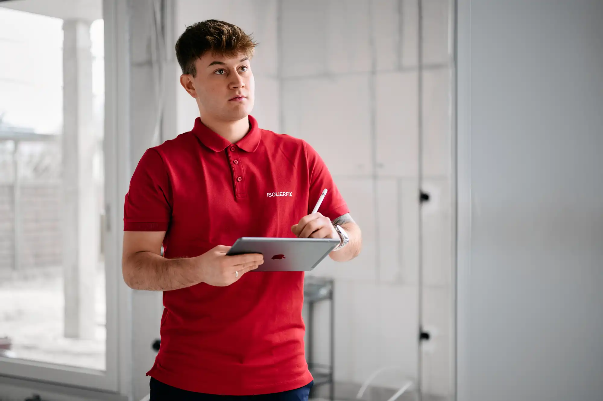 ISOLIERFIX-Mitarbeiter mit Tablet auf der Baustelle, beide schauen gemeinsam auf ein Tablet – Szene aus einer Unternehmensreportage im Handwerk.