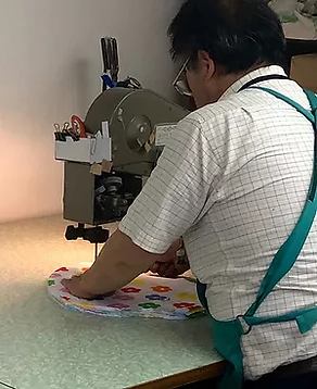 ミシンで作業している男性