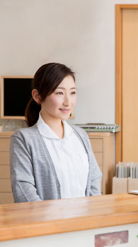 受付の女性と会話している患者