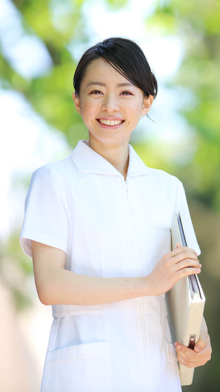 緑の中に立つ看護師