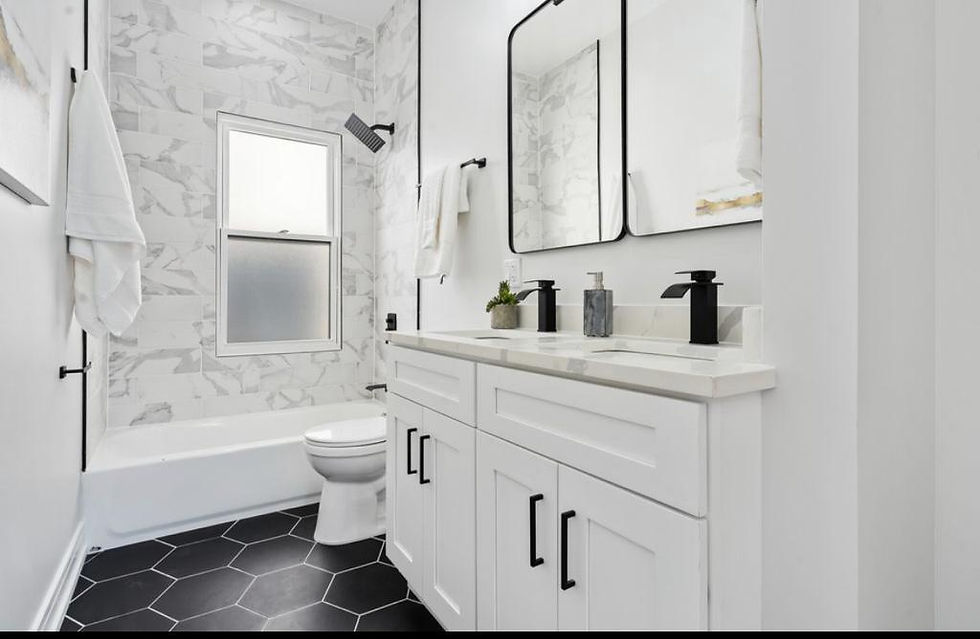 Secondary bathroom with a spacious double vanity, granite tilework, matte black flooring and hardwar