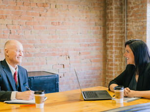 A lawyer meets a client, who takes notes.