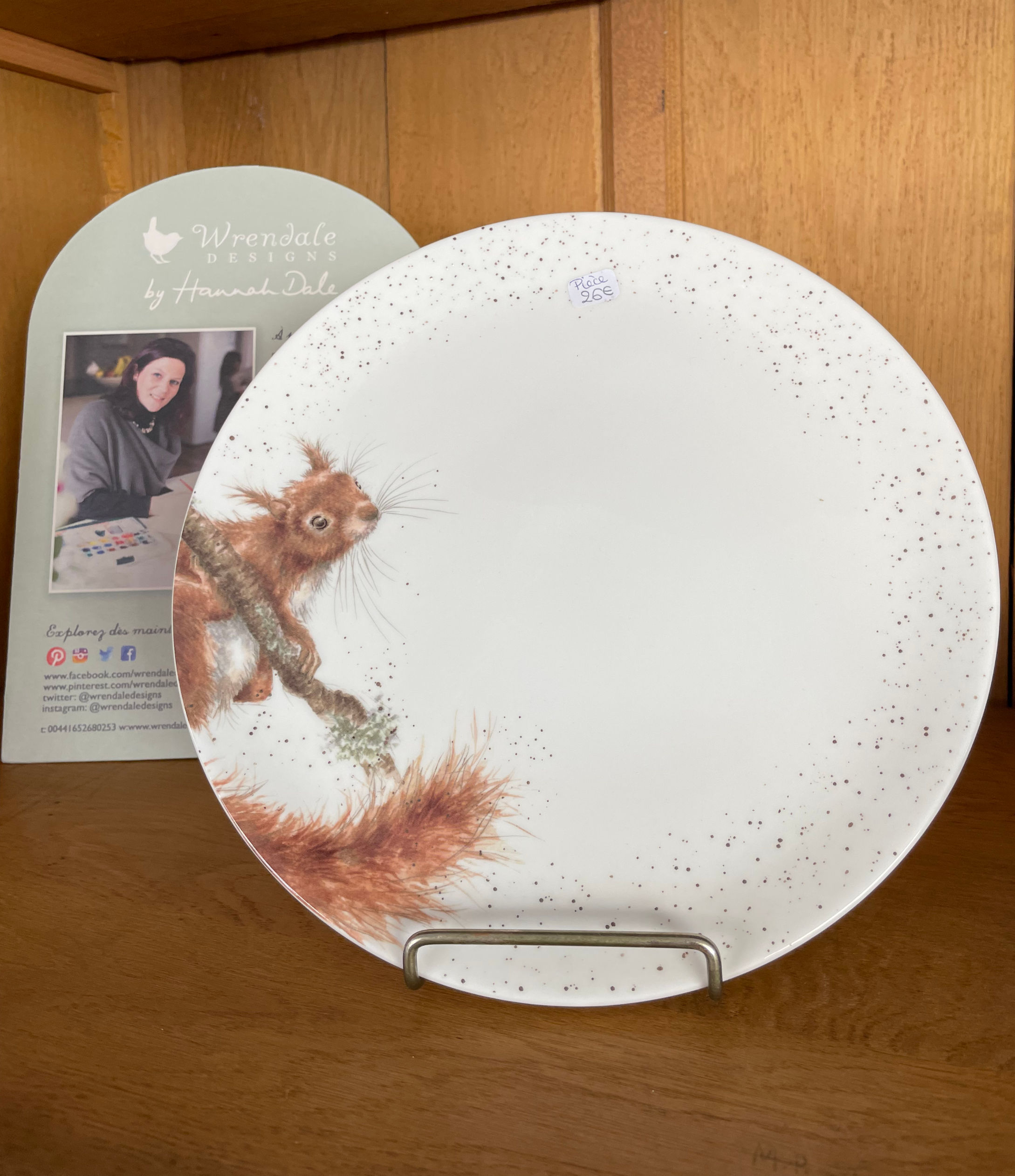 Assiette en porcelaine blanche avec un écureuil marron sur le côté.