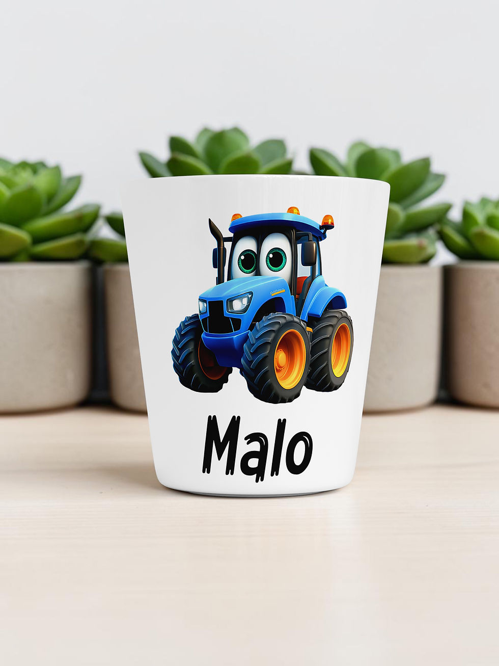 Miniature : Un gobelet en plastique blanc orné d'un tracteur bleu de dessin animé avec de grands yeux et des roues orange.