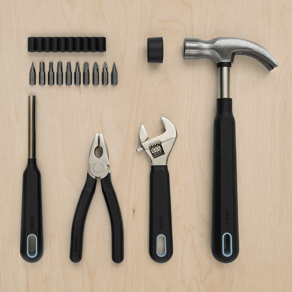 Tools on wooden surface: hammer, pliers, adjustable wrench, screwdriver, and bits. Black handles, organized layout, neutral background.