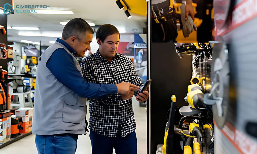 Two men in a store, one in a blue shirt, the other in a checkered shirt, discussing a product near shelves of yellow tools. Logo: Diversitech Global.