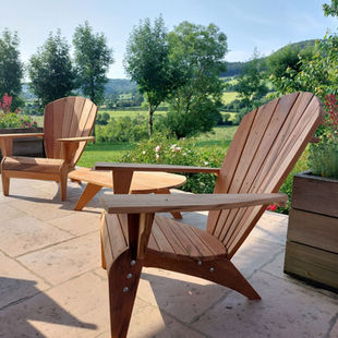 Un couple de Fauteuils Adirondack Verneuil, en muiracatiara, accompagné d'une Table Basse, en Aveyron.