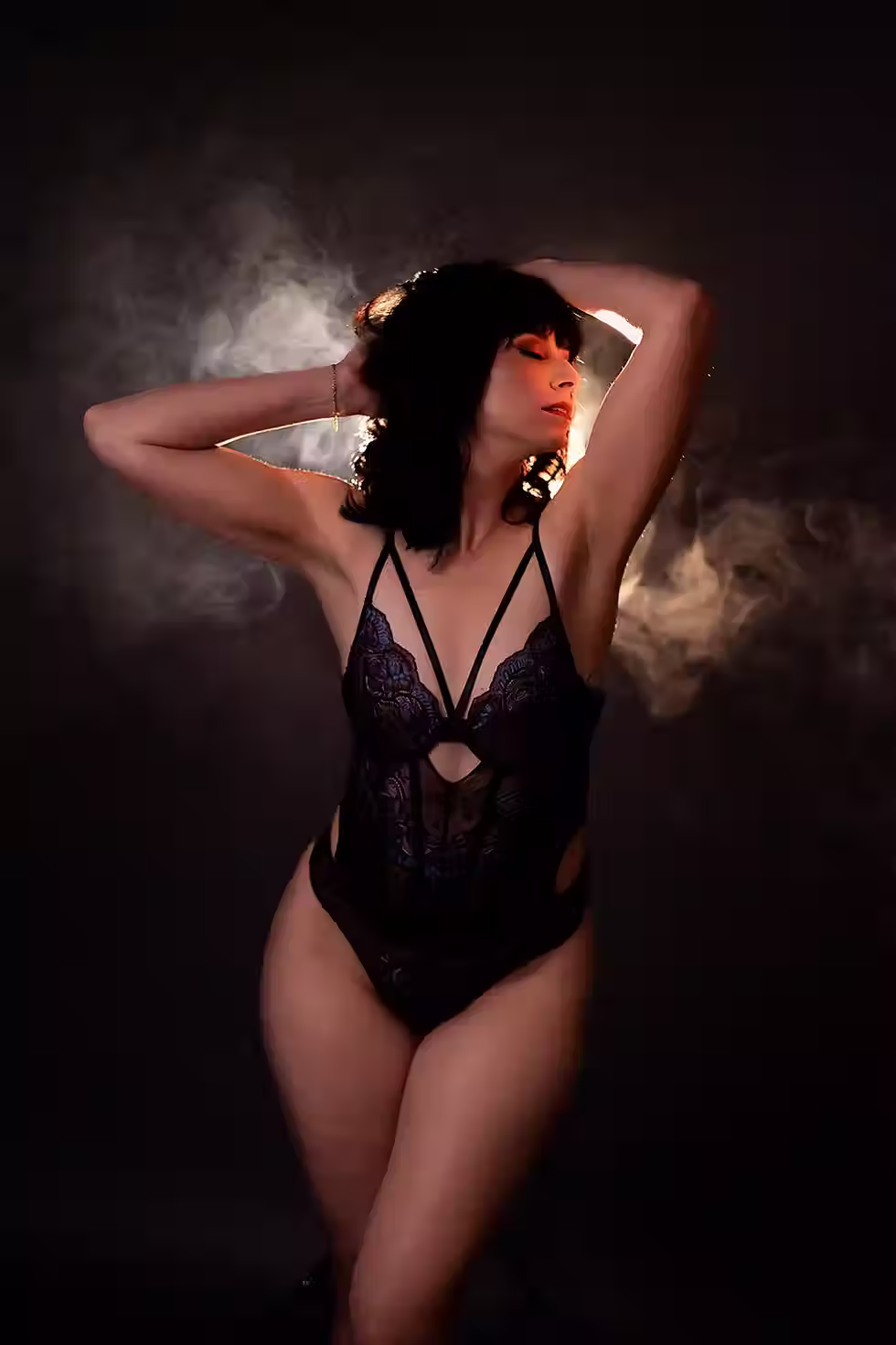boudoir photography minneapolis woman wearing lingerie posing in front of smokey lighting