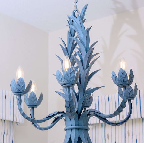 Detail of statement chandelier in blue finish with botanical metal design