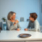 American mom middle age sitting by large white dinning table holding medication showing compounding medication