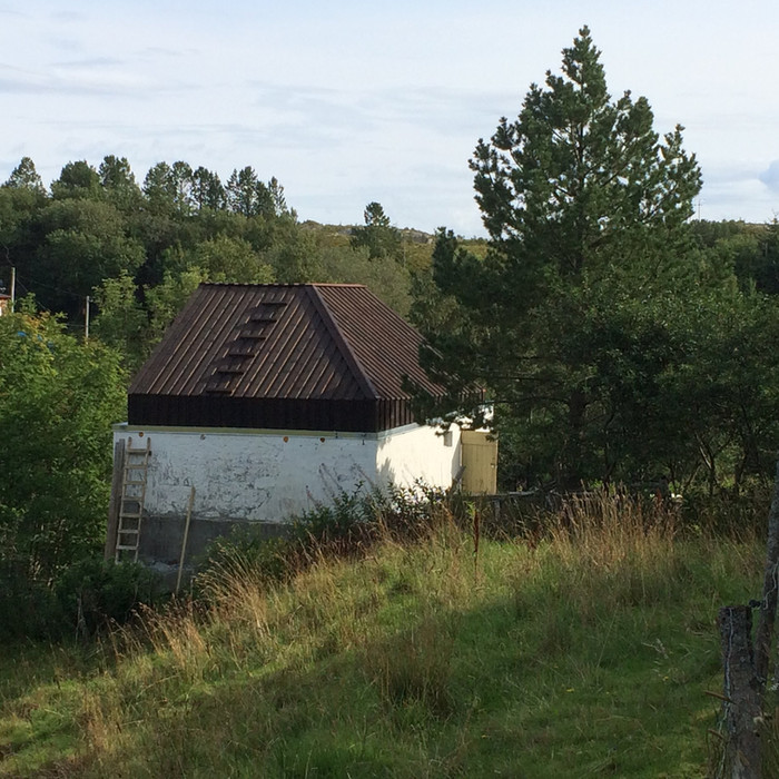 Eksteriørbilde av Atelier Edvine som ligger mellom trærne på Stokkøya, Trøndelag.