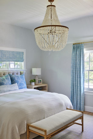 The primary bedroom room of a renovated Hamptons home designed by Britt Design Studio.  The decor is bright and luxurious with an infusion of color and luxury.
