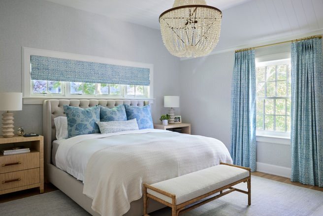 The primary bedroom room of a renovated Hamptons home designed by Britt Design Studio.  The decor is bright and luxurious with an infusion of color and luxury.
