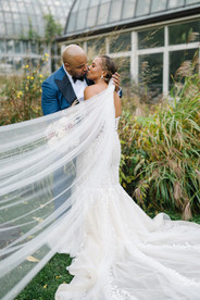 Newlyweds pose in greenery.