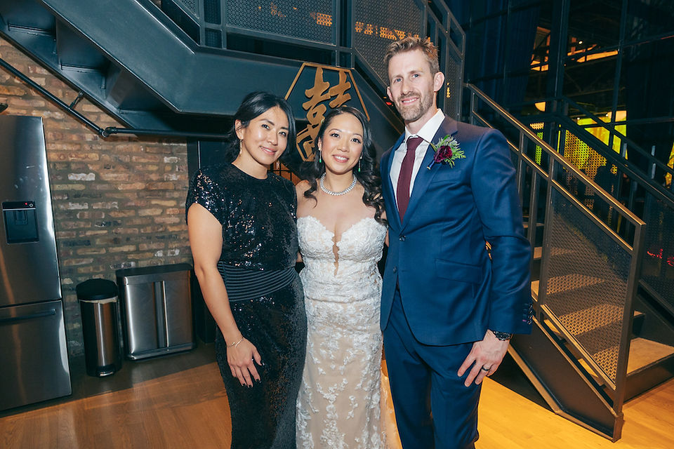 Newlyweds smile with wedding officiant.
