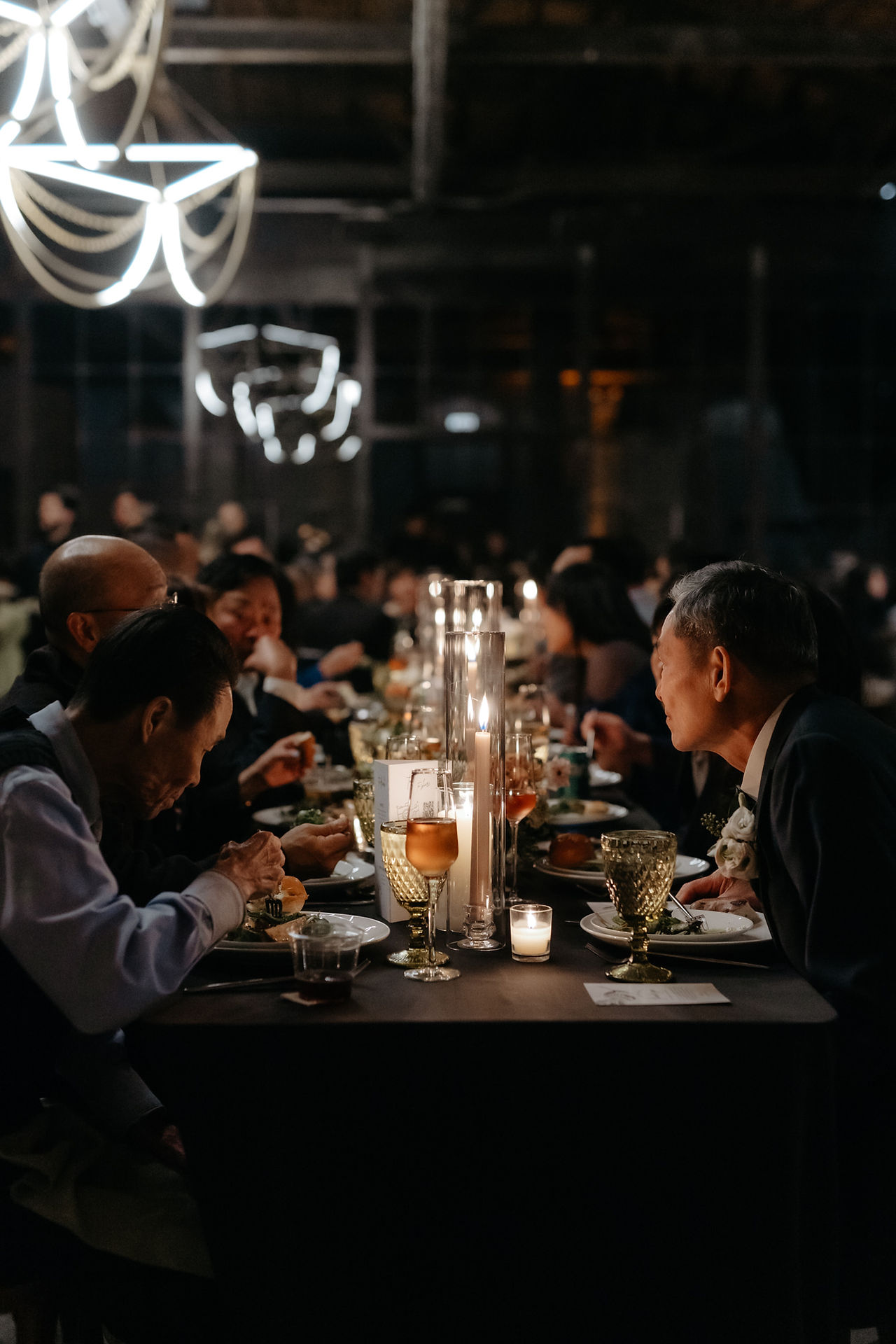 Candlelight and chandeliers accent a lofty dinner reception.