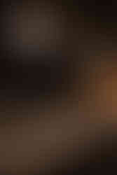 Modern wedding reception tablescape with candlelight, white florals, and dramatic industrial chandeliers at Chicago venue.