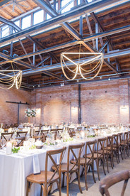 Long banquet tables set for wedding reception with candles and floral centerpieces.