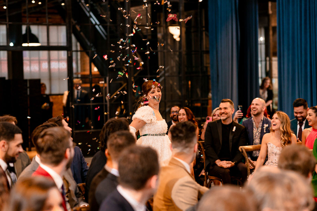 Flower girl throws confetti down aisle.