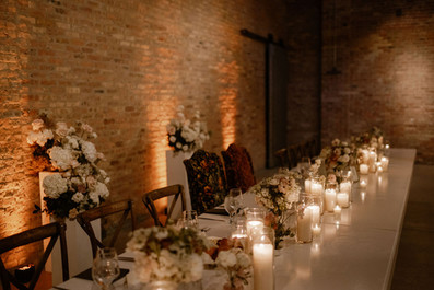Rich candlelight and florals on headtable.