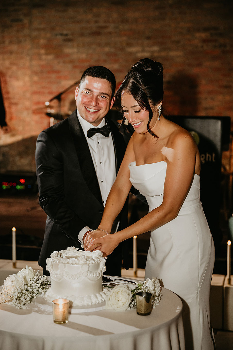 Couple cuts white wedding cake at Wildman BT.