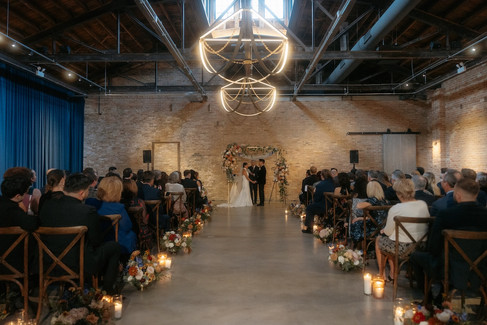 Wide ceremony view with floral arch and modern chandelier at Wildman BT Chicago wedding.
