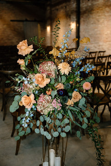 Colorful fall wedding floral arrangement with roses and blue delphinium at Wildman BT.