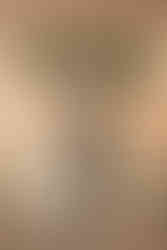 Newlyweds share kiss at head of aisle.