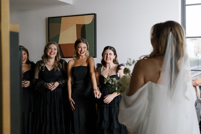 Bridesmaids reacting to first look of bride in her dress.