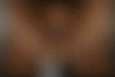 Bride walking down aisle of historic cathedral with stained glass and chandeliers in Chicago.