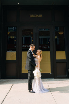 Bride and groom pose outside industrial city building