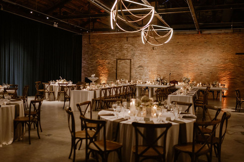 Chandelier lit dinner reception with combination of long and round tables.