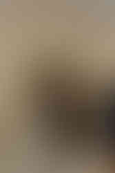 Bride and groom exchange vows beneath floral arch.