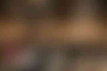 Wedding reception toast moment inside exposed brick venue with glowing modern chandeliers.