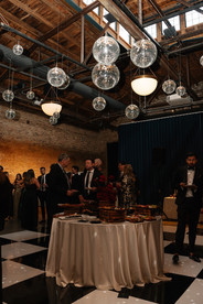 Cocktail hour with disco balls and guests mingling on black and white dance floor in Chicago loft.