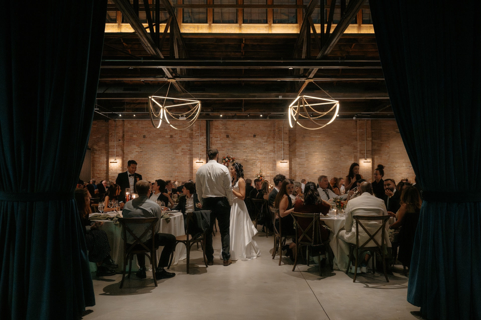 Bride and groom greeting guests during dinner reception at Chicago industrial venue.