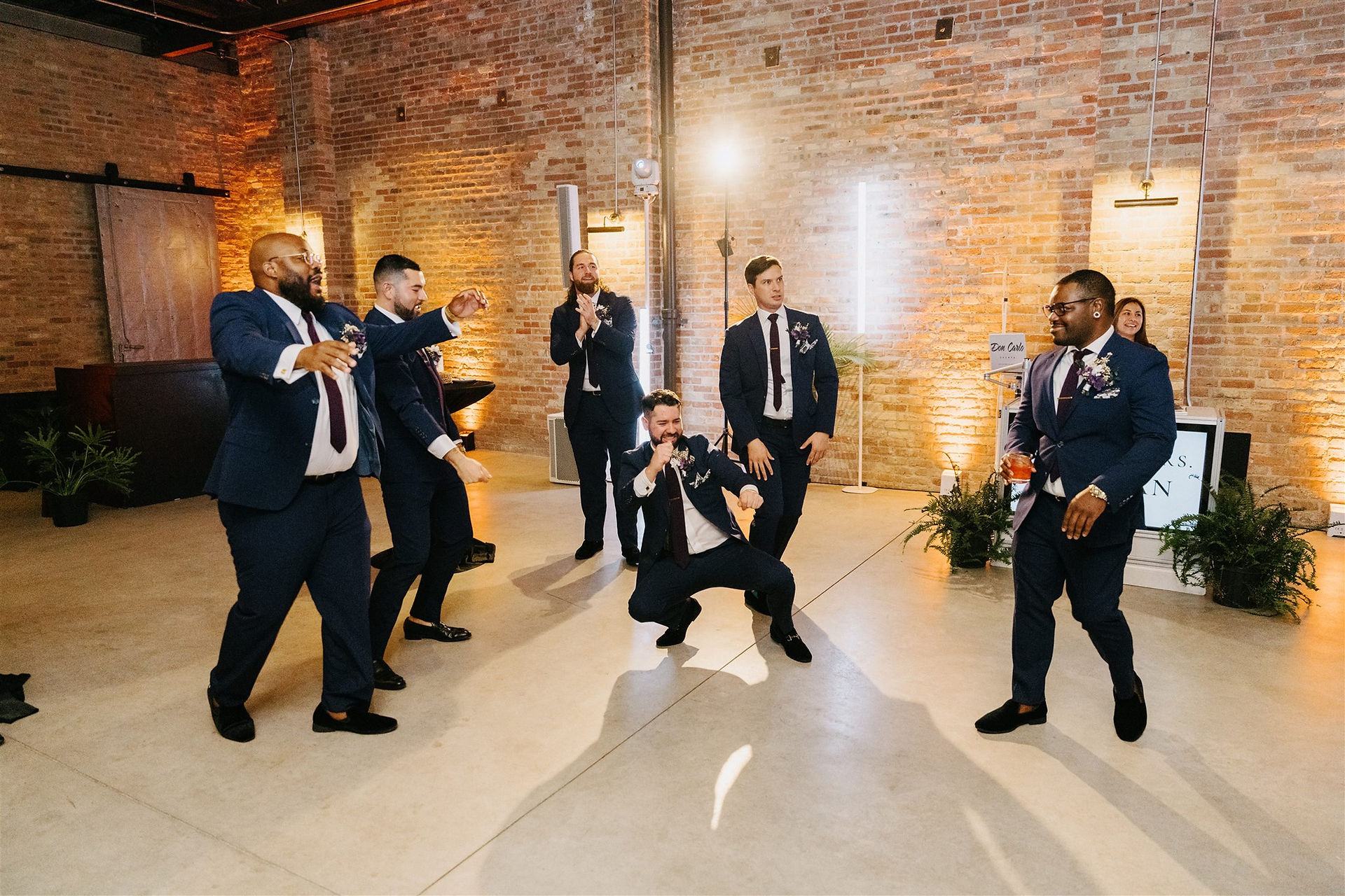 Groomsmen doing entrance dance at industrial loft.