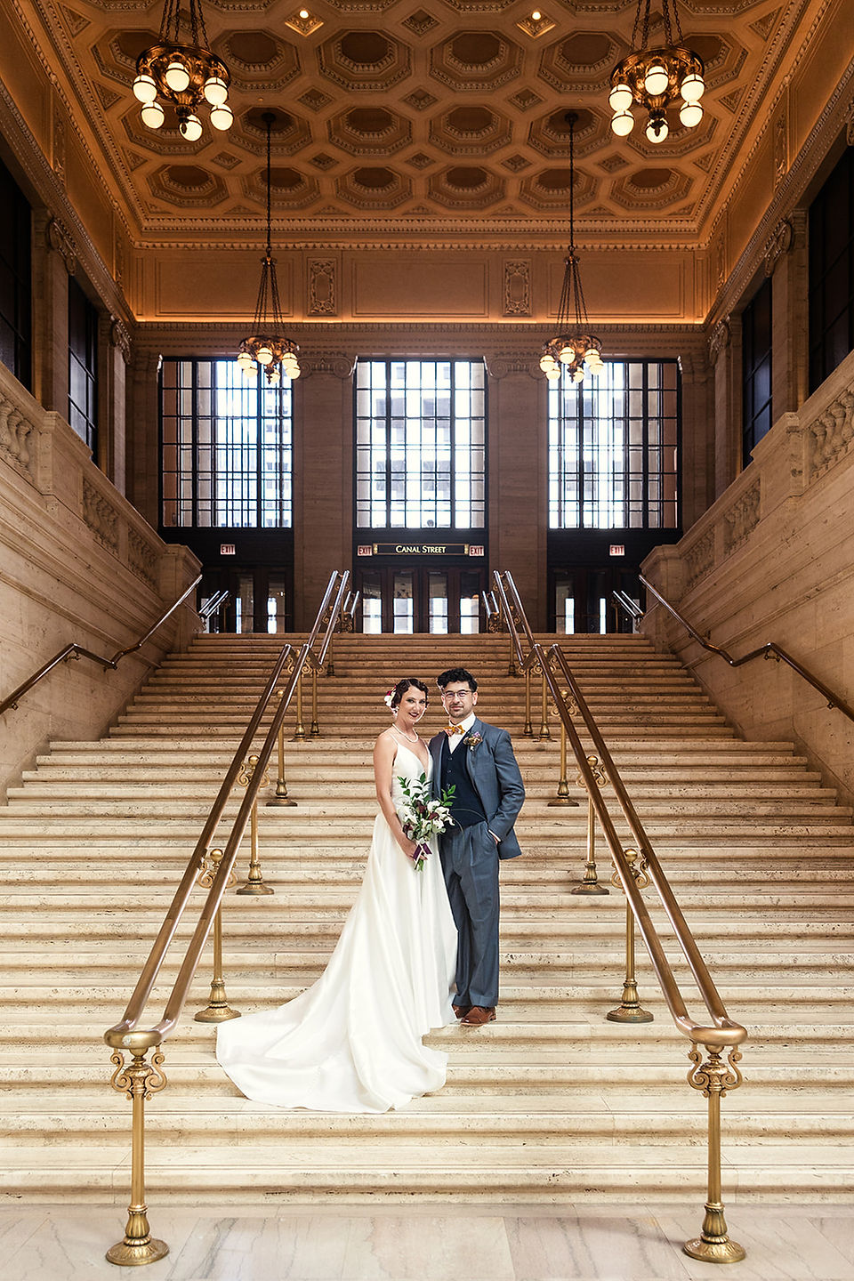 Bride and groom portrait on grand staircase at Chicago historic wedding venue.