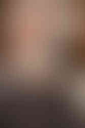 Newlyweds kissing at sweetheart table surrounded by candles and calla lily centerpiece.