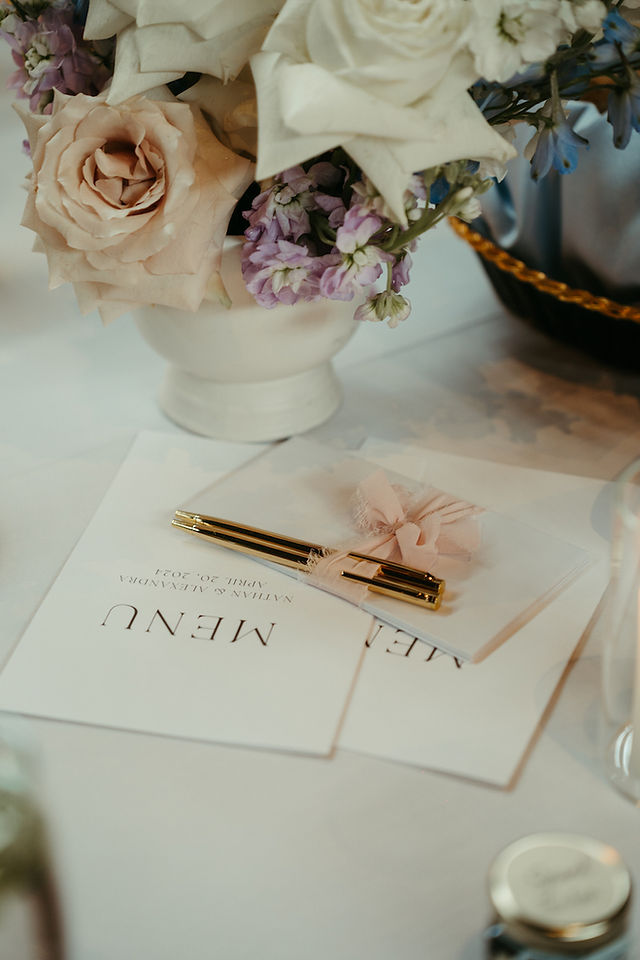 Flat lay of elegant menus with blush and gold accents.