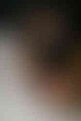 Bride and groom touching noses with colorful fall bouquet.