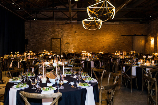 Table settings with candles and greenery at Chicago industrial wedding.