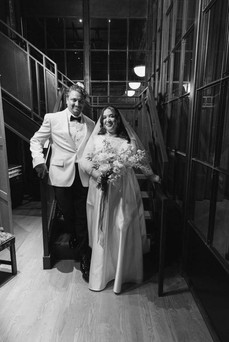 Black and white photo of bride and groom in loft. 
