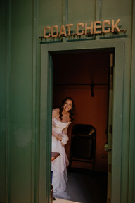 Bride sneaks through coat check to do first look.