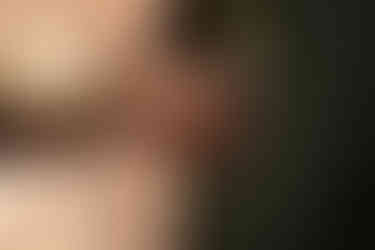 Groom places wedding band on brides hand.