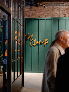 Gold sign of couples last name with lush green backdrop. 