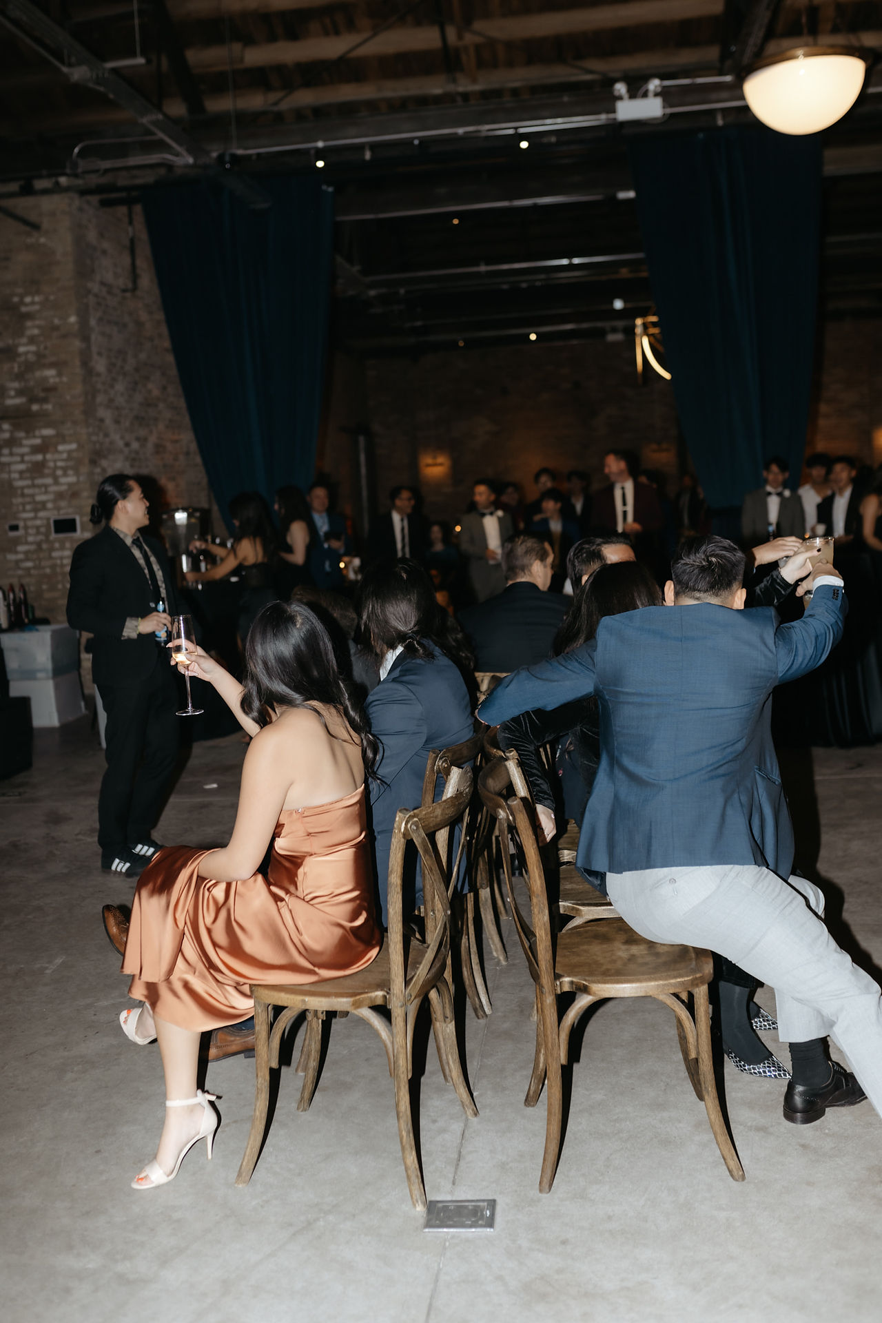 Guests play musical chairs at wedding reception.