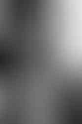 Bride applying perfume while getting ready in Chicago loft with exposed brick walls.