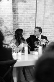 Intimate laugh shared between bride and groom at dinner.